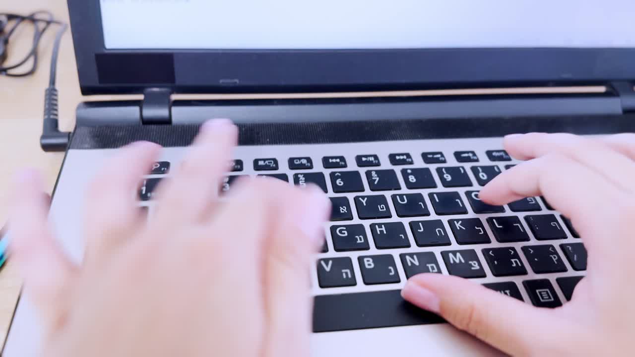 Front view of hands typing on a laptop keyboard, facilitating modern digital communication