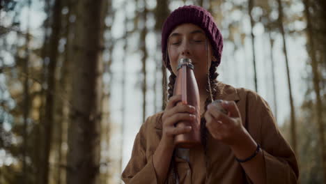 female tourist smelling coffee from thermos