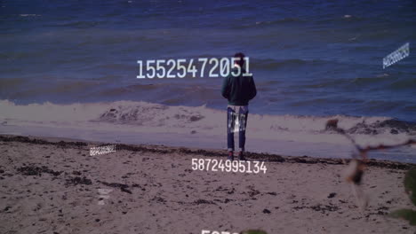person standing on beach with numerical data animation over ocean background