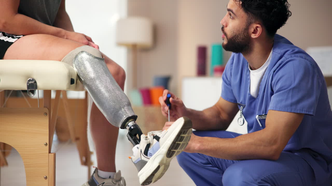 un fisioterapeuta ayuda a un paciente con una pierna protésica a ponerse un zapato.