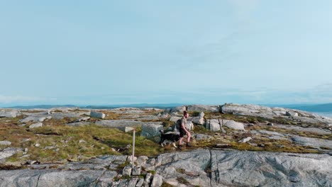 Hombre-Acompañado-Por-Un-Perro-Navegando-Por-El-Terreno-Cerca-De-Rissa-Y-Hasselvika-En-La-Montaña-Bla-Heia-En-Noruega---Computadora-De-Mano