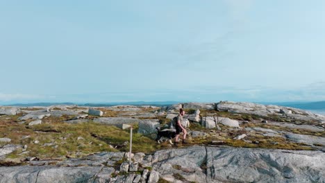 hombre acompañado por un perro navegando por el terreno cerca de rissa y hasselvika en la montaña bla heia en noruega - de mano