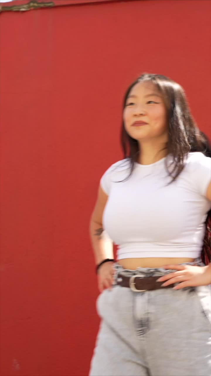Woman posing in front of a red wall