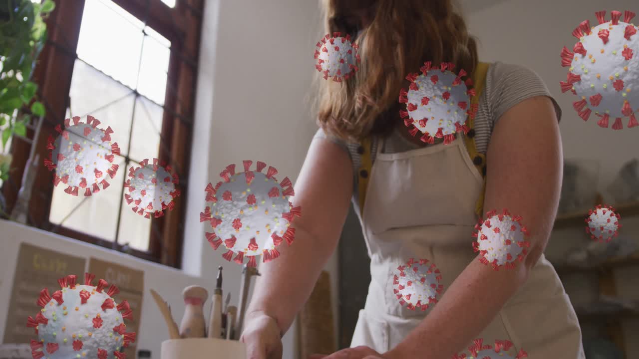animación de células de covid-19 sobre una mujer que trabaja en un estudio de cerámica con una máscara facial