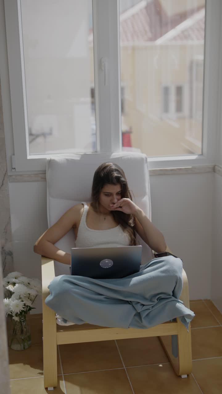 mujer trabajando en una computadora portátil en un balcón