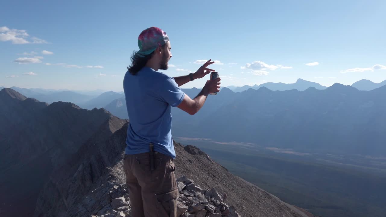 caminante abriendo cerveza en pico en la cordillera rocosa kananaskis alberta frontera de columbia británica canadá