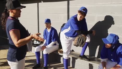 Vielfältige-Gruppe-Weiblicher-Baseballspieler-Und-Trainer,-Trainer,-Der-Spieler-Auf-Der-Bank-Unterrichtet