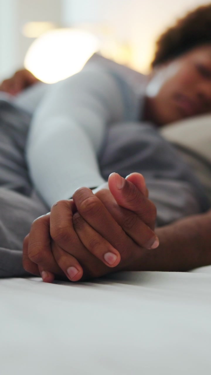 Couple Holding Hands While Sleeping in Bed