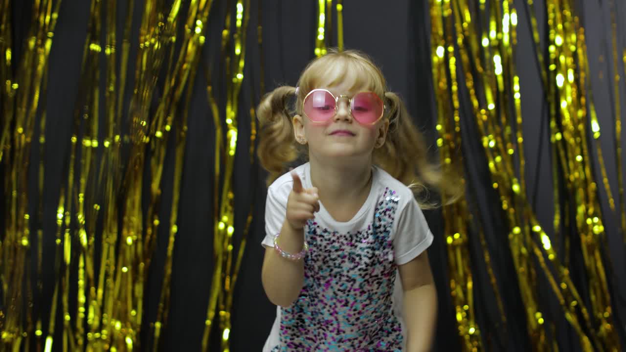 멋진 아이 춤을 추고, 얼굴을 만들고, 어리석은 춤에서 손을 흔들고, 작은 금발 소녀 4-5 살