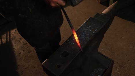 mid-section of blacksmith working on a iron rod