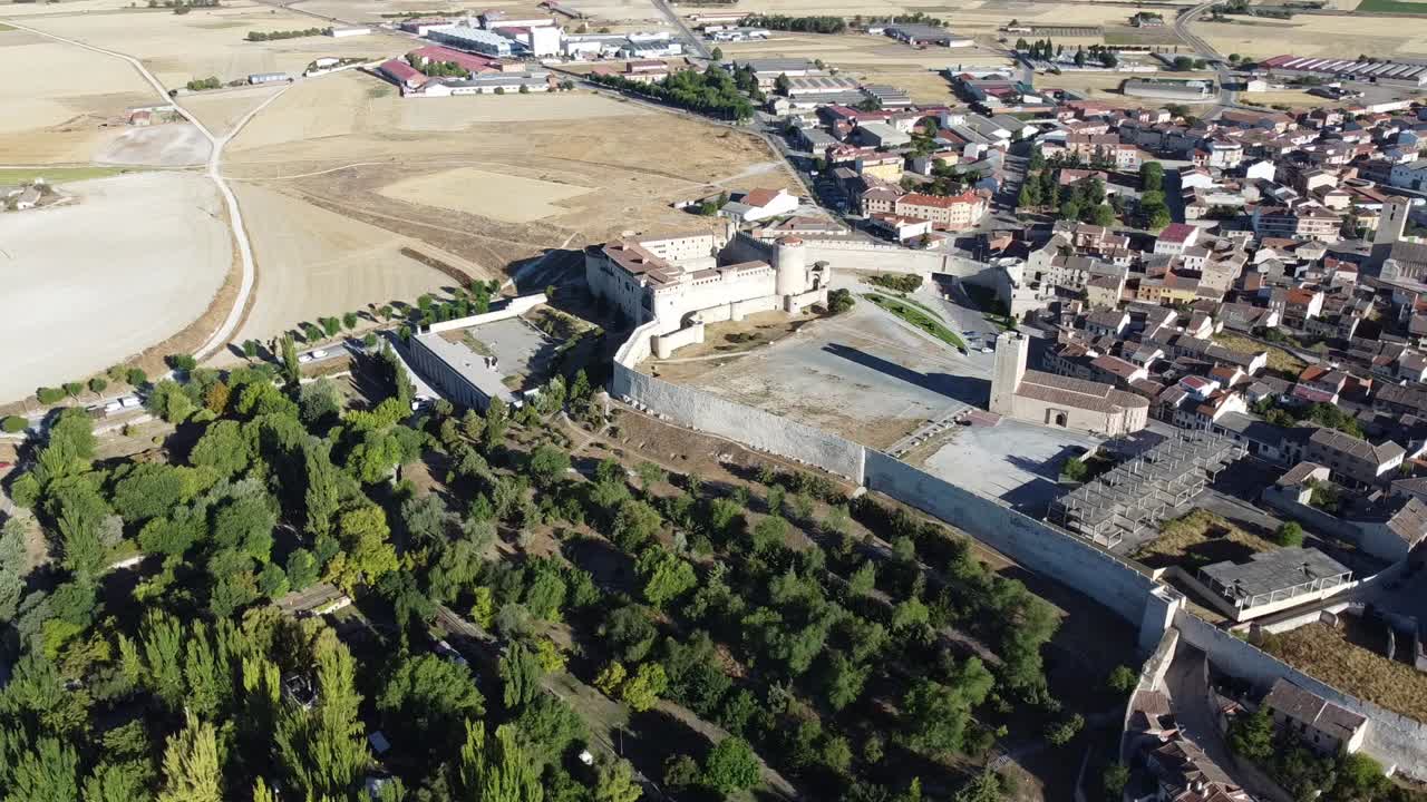 vista aerea orbitale del castello medievale con mura difensive, foresta, giardini e vecchie case