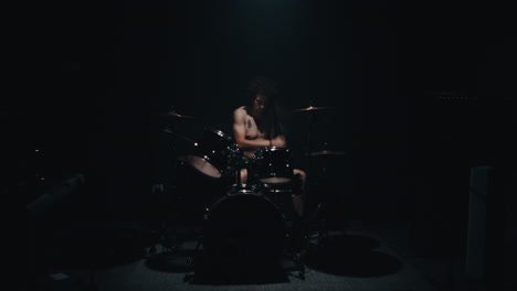 drummer performing in a dark studio
