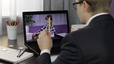 hombre haciendo una llamada de video en la computadora portátil con un pequeño alumno. educación a distancia