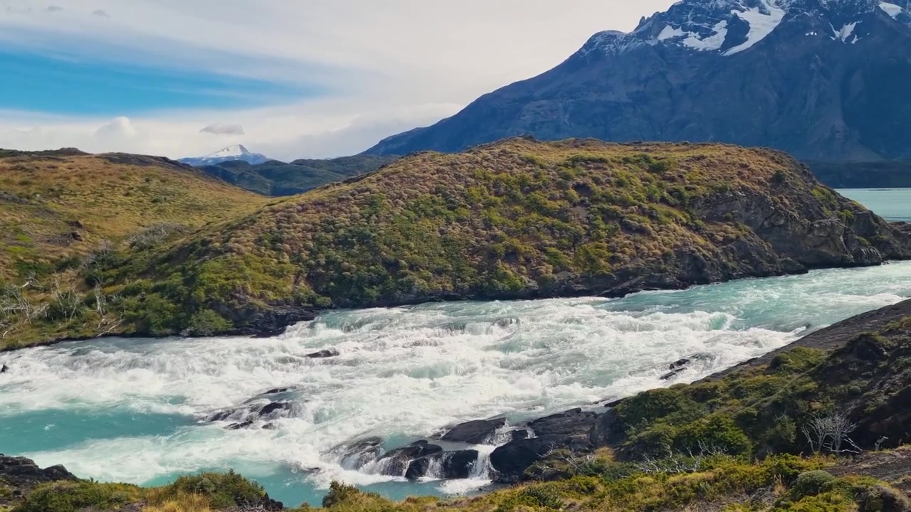 Il Lago Nordenskjöld sfocia nel Lago Pehoé nel Parco Nazionale Torres del Paine, Cile, circondato da montagne aspre e cime innevate nella natura incontaminata della Patagonia