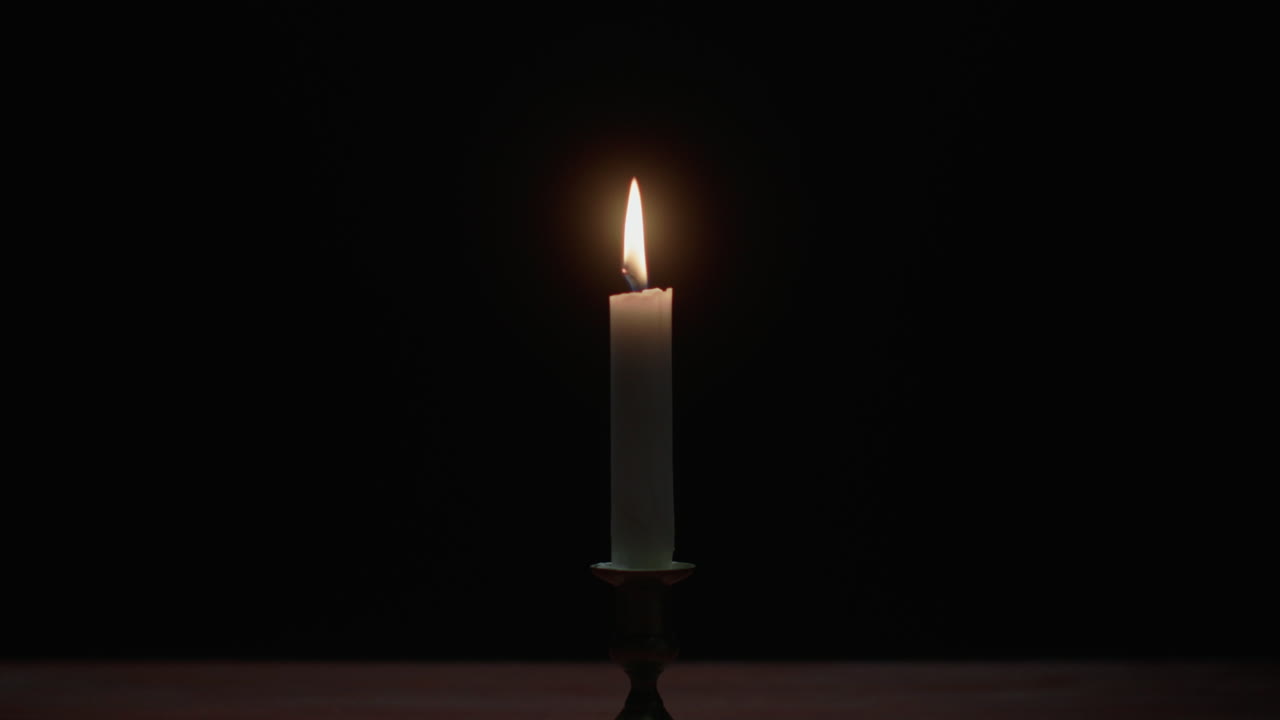 Una candela si spegne nella stanza buia
