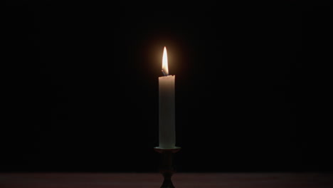 a candle burs out in the dark room