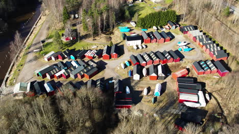 fishing cabins clustered in forest next to sea, bohuslan, sweden, aerial circling