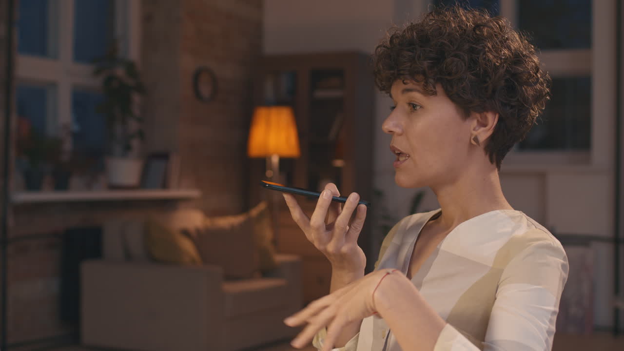 mujer usando asistente de voz en el teléfono inteligente en casa