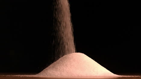 sugar pouring on black background