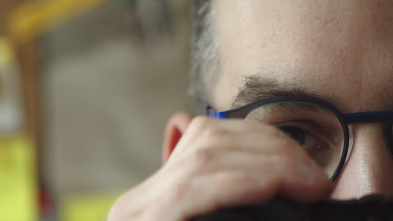 mitad de rostro masculino, ojo, gafas mirando a través de binoculares, vista frontal extrema de cerca, espacio de copia