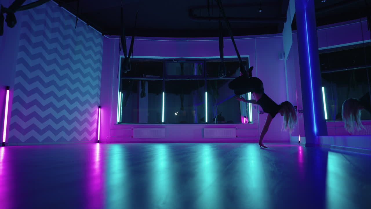 mujer se balancea en hamaca para volar-yoga en clase colgando la cabeza hacia abajo estiramiento y fitness