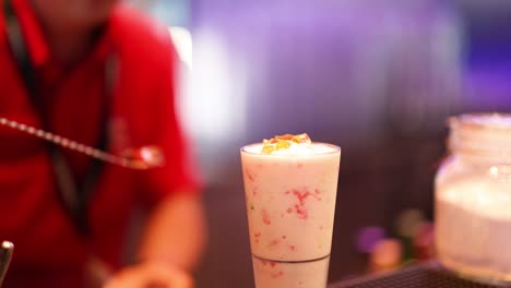 bartender preparing a smoothie with toppings