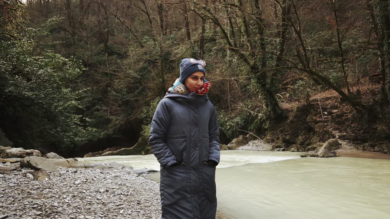 숲 속 의 겨울 강 을 따라 산책 하는 여자