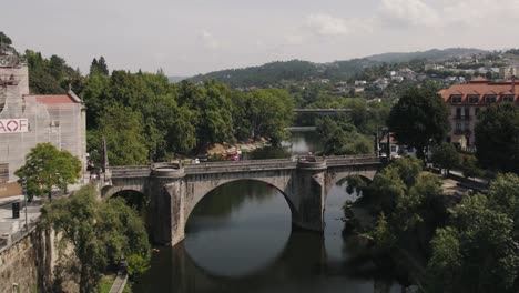 Beautiful-scenery-shot-of-ancient-Sao-Goncalo-bridge-and-perfect-water-reflection-on-a-tranquil-day