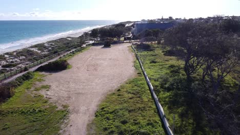 aerial pull back view over quinns rocks caravan park site with pristine coastline on bright sunny day