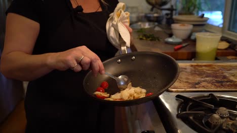 a chef mixes ingredients in a pan