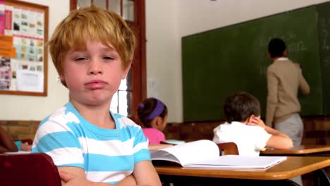 niño aburrido soplando a través de los labios durante la clase