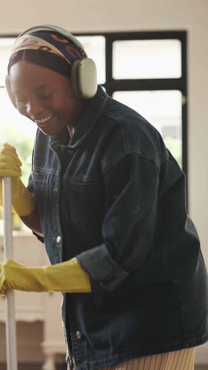 Happy Young Woman Mopping Floor While Listening to Music