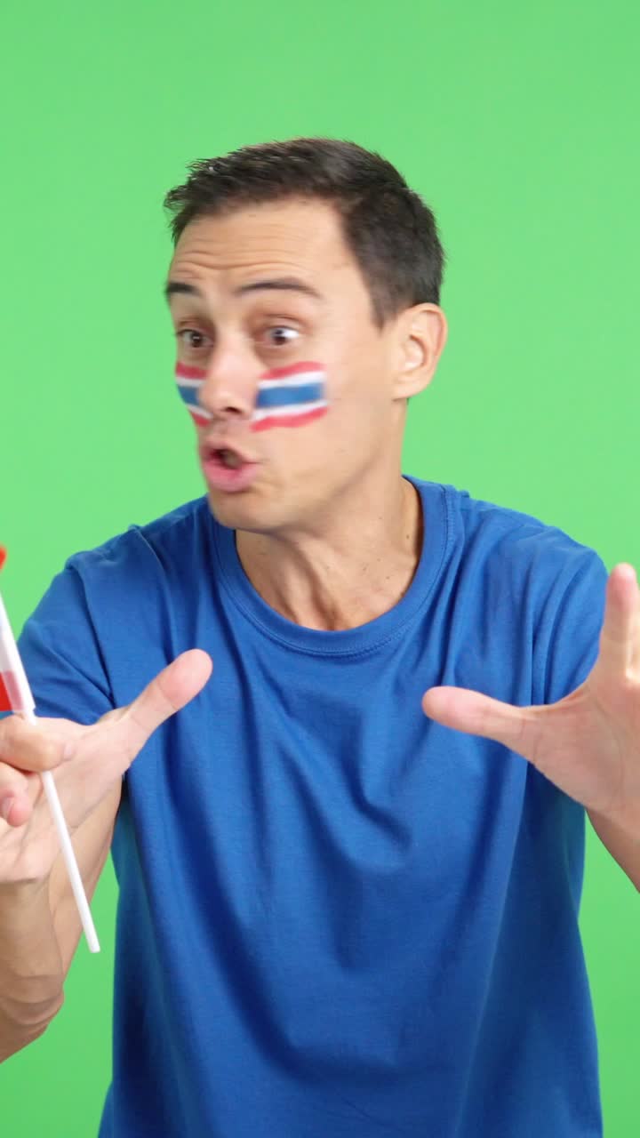 Man cheering for Thailand screaming and waving a national flag