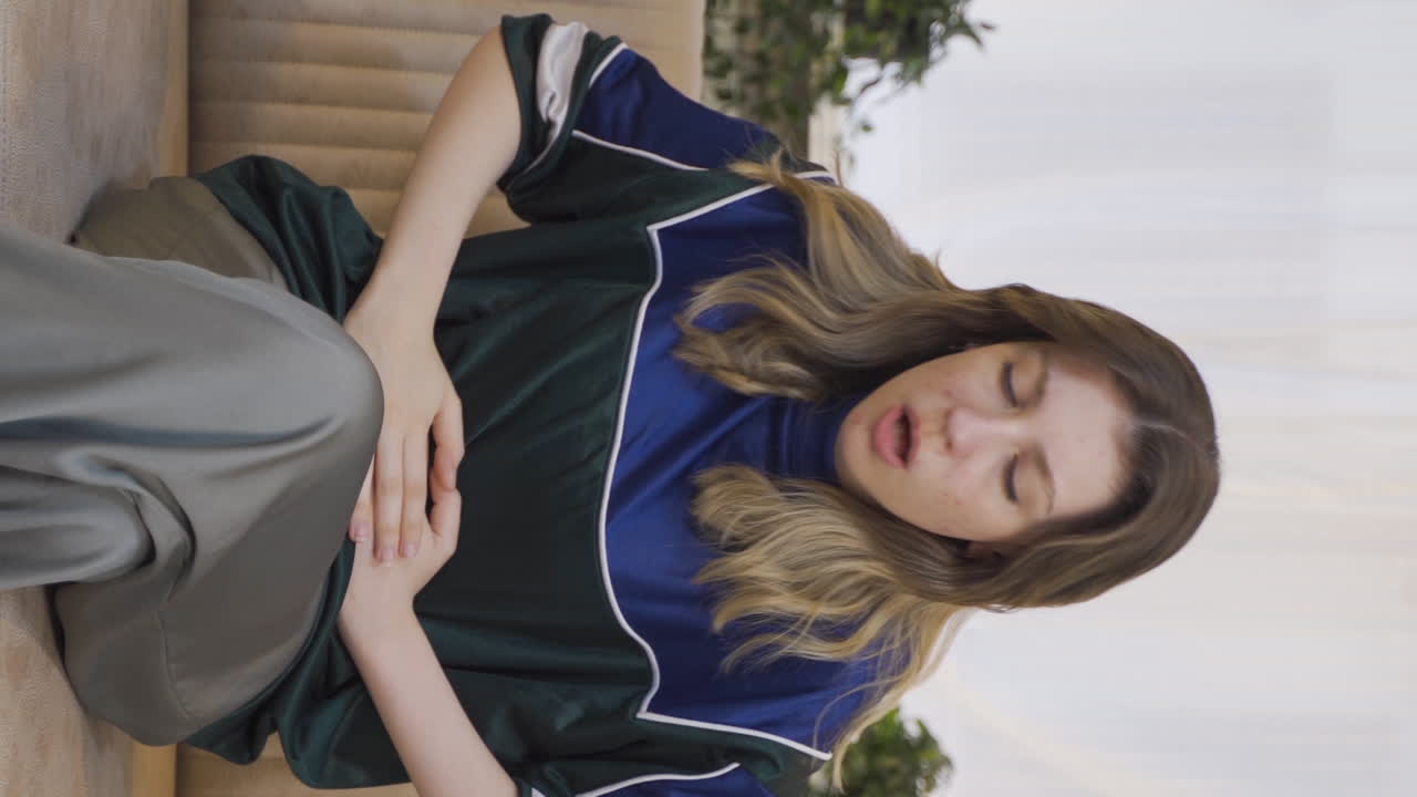 메스꺼움이 있는 젊은 여성의 수직 비디오.