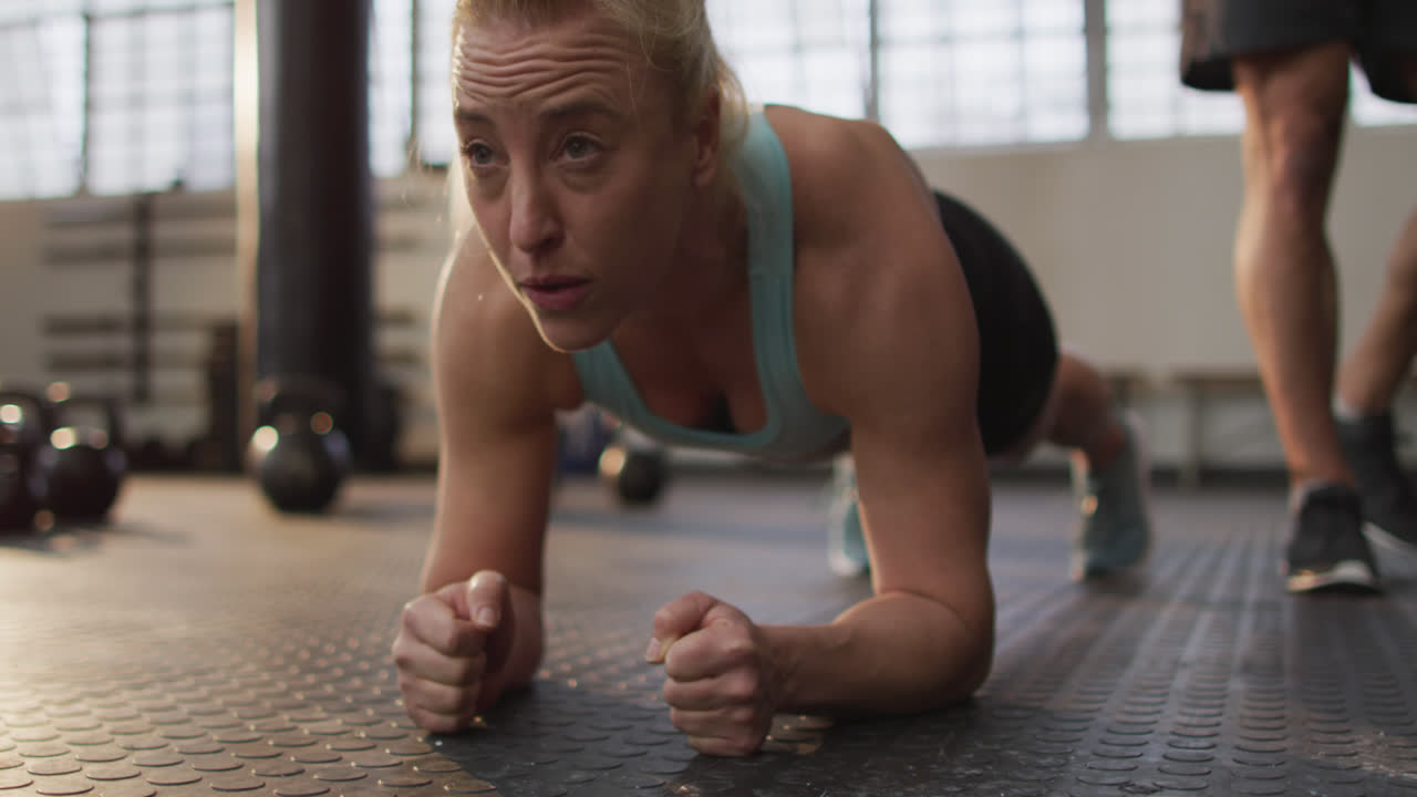 Close up of fit caucasian woman performing plank exercise at the gym