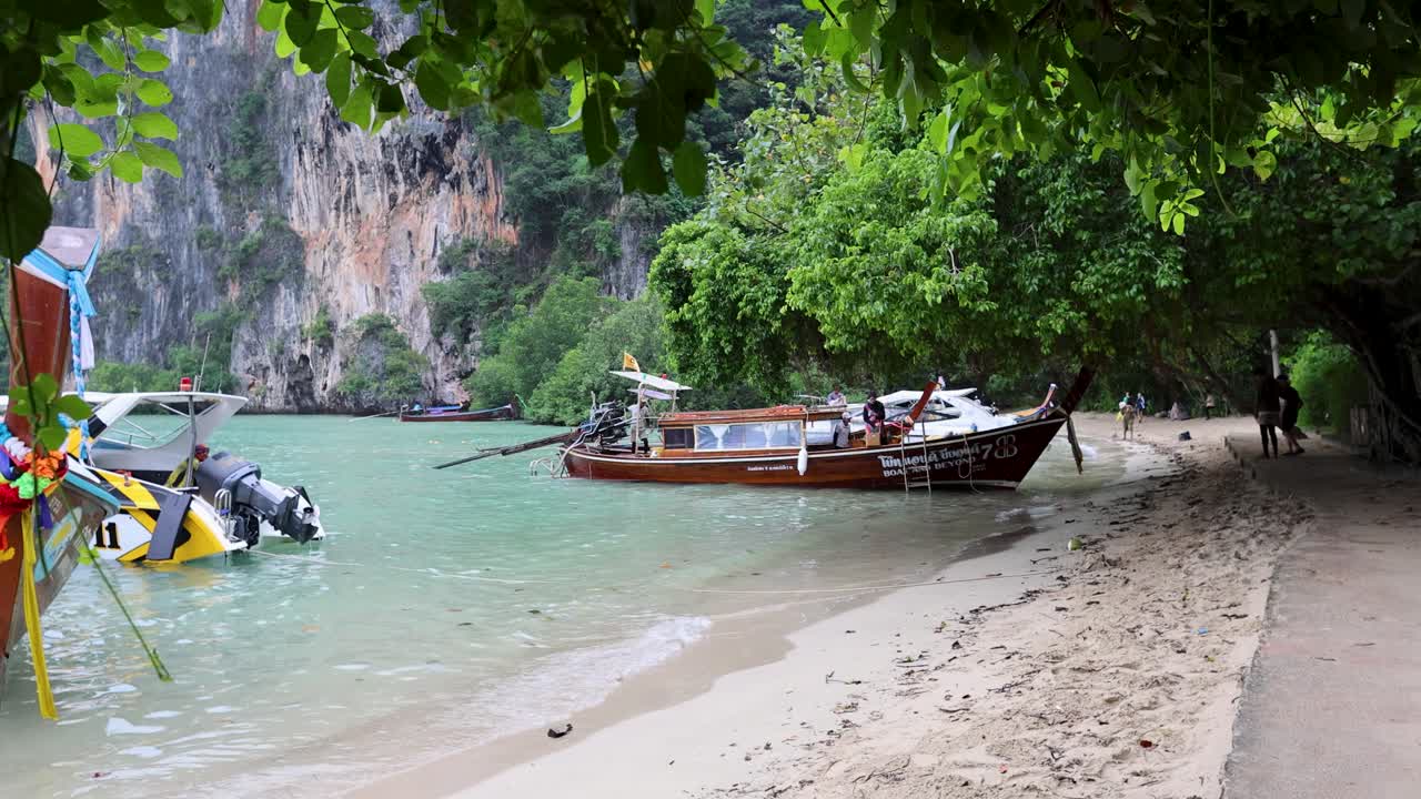 Una barca si avvicina alla riva nel paesaggio scenografico di Krabi