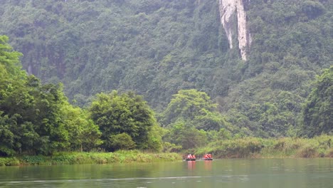 boats glide through lush, mountainous landscape