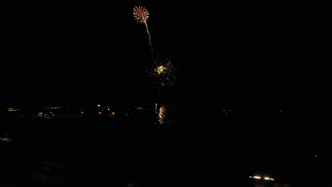 antena de fuegos artificiales sobre un pequeño pueblo con luna