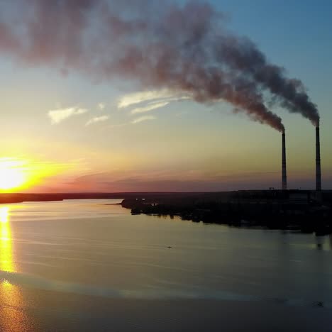 humo de la fábrica de tubos cerca del río