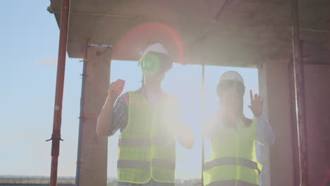 dos trabajadores de la tripulación contemporánea usando vr para visualizar proyectos de pie en un edificio inacabado en el sitio de construcción espacio de copia
