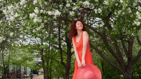 woman in a red dress walking in a blooming park