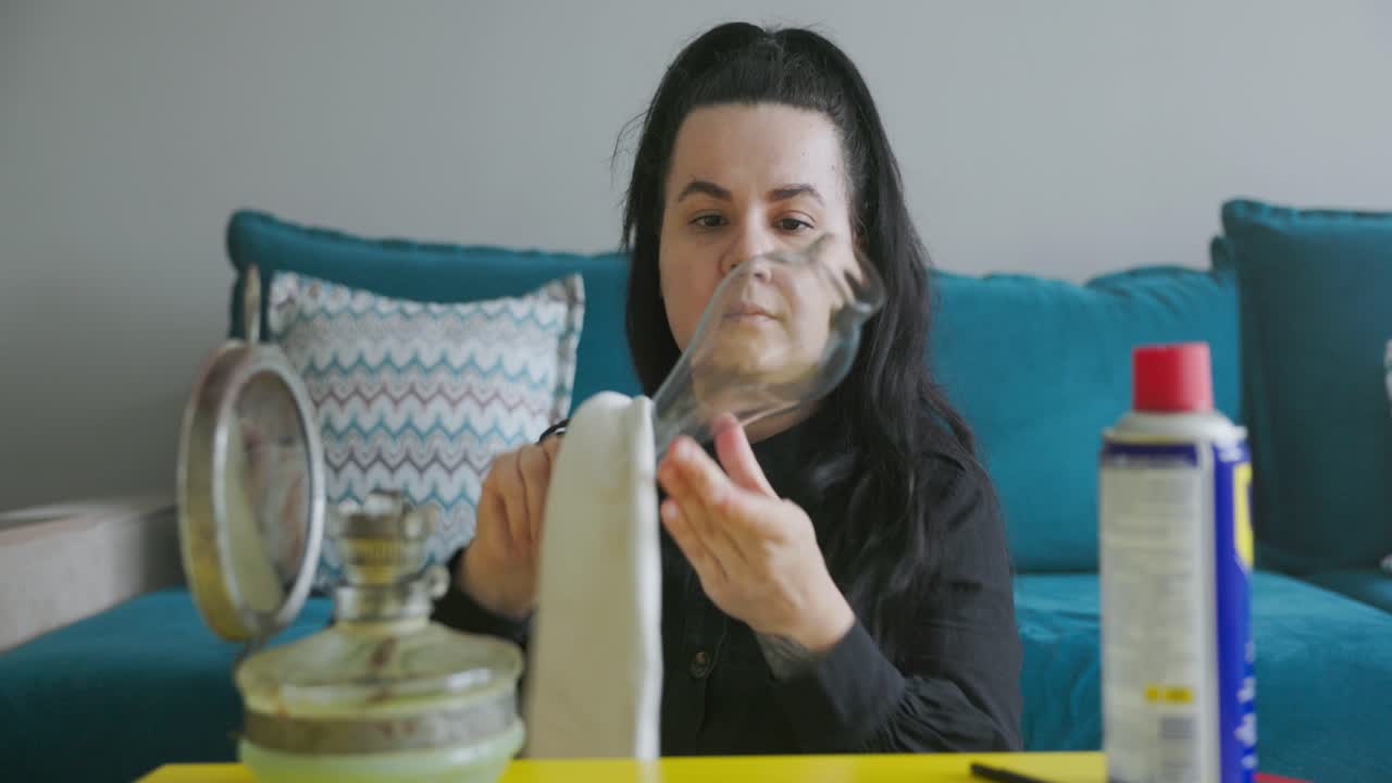 mujer limpiando una vieja lámpara de gas de época - de cerca