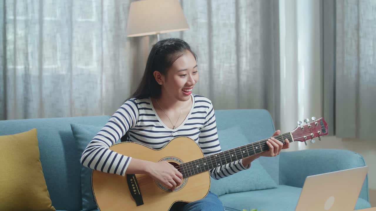 집에서 어쿠스틱 기타를 연주하는 여자