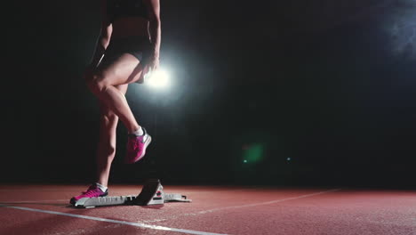 athlete woman in black shorts and a t-shirt in sneakers are in the running pads on the track of the sports complex and run in slow motion