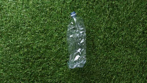 Close-up-of-plastic-bottle-trash-on-grass-background,-with-copy-space