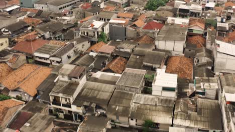 aerial tilt down shot of old destroyed roof of slum buildings in jakarta city, indonesia