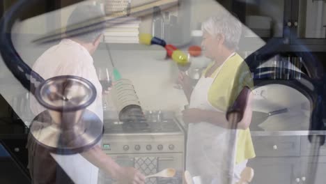 Stethoscope-and-syringe-spinning-against-senior-couple-cooking-in-the-kitchen-at-home