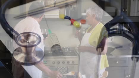 estetoscopio y jeringa girando contra una pareja de ancianos cocinando en la cocina en casa
