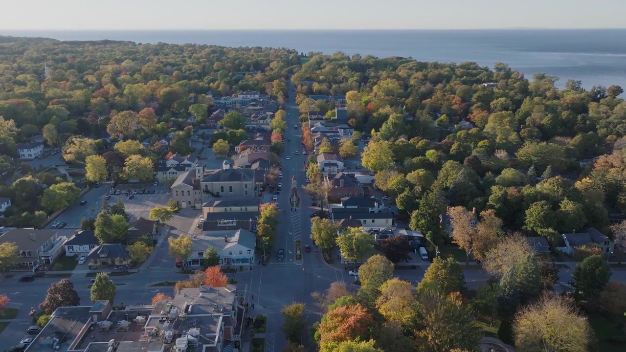 Sonbaharda Niagara-on-the-Lake'teki Queen Caddesi üzerinde uçan bir drone, tarihi binalar arasında renkli sonbahar ağaçlarıyla çevrili Anıt Saat Kulesi'ni gösteriyor.