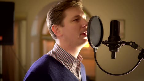 a man sings into a studio microphone